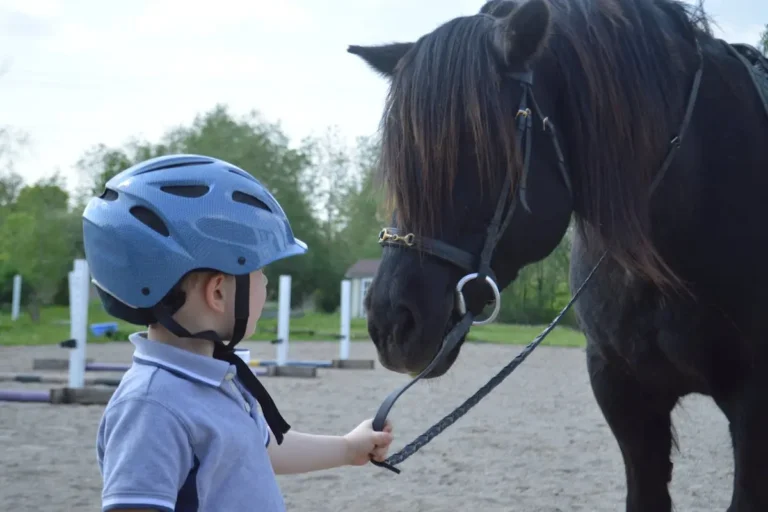 A young girl learning horseback riding with an instructor.