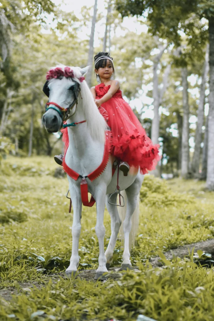  A young girl learning horseback riding with an instructor.