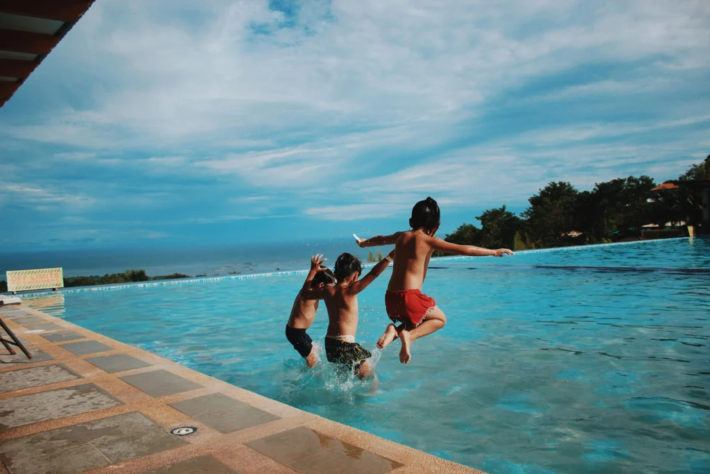 A young child learning to swim in a pool with a supportive instructor, focusing on safety and building confidence in the water.