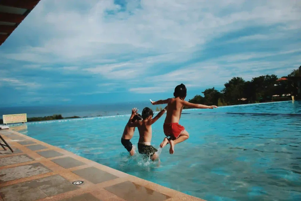 Swimming as a Life Skill , A young child learning to swim in a pool with a supportive instructor, focusing on safety and building confidence in the water.